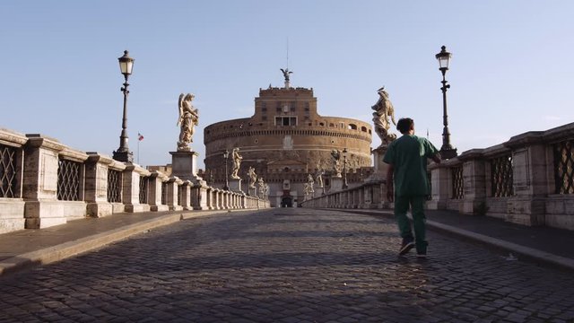 In a semi-abandoned Rome a survivor walks towards "Saint Angel Castle" Castel Sant Angelo and bridge Ponte Sant Angelo over the Tiber river. Shot on Red Monstro 8K. In 4K