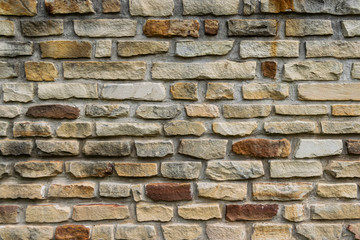 Pattern of tan and brown stone bricks in wall