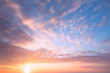 Beautiful sunset, bright sun and soft, multicolored clouds.