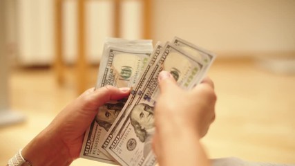 Happy woman counting dollar bills. The man got the money. the person got paid. Closeup of female hands counting cash money. Calculation of money. Happy wife received money from her husband. - Powered by Adobe