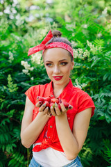Beautiful young pin up girl with bright make up and fresh natural strawberry.