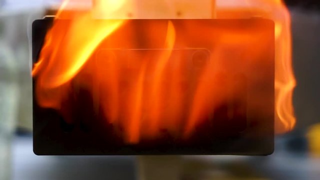 Slow motion hand held shot of a yellow flame firing out the back of a table top pizza oven, flame coming out of a grill.