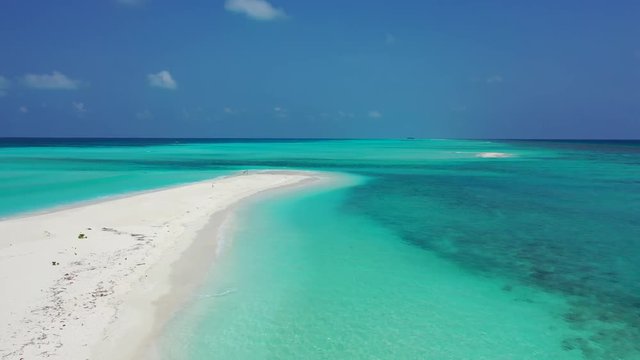 Aerial view of an elongated white strip pf sand surrounded by azure waters in the Barbados