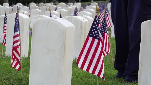 Man Walks up to Military Headstone