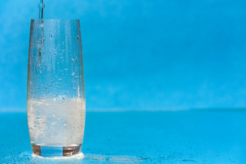 A stream of mineral water pouring into a glass