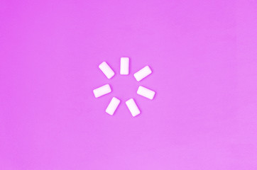 A few chewing gums lie on texture background of fashion pastel purple color paper