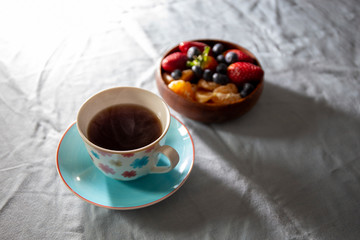 Strawberry, blueberry and madarin in wooden basket with coffee