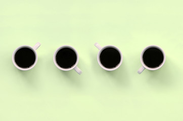 Many small white coffee cups on texture background of fashion pastel lime color paper