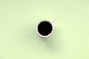 Small white coffee cup on texture background of fashion pastel lime color paper