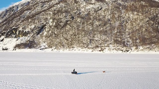 Cruising through winter snow trails of Valdez Alaska in a snowmobile, drone shot