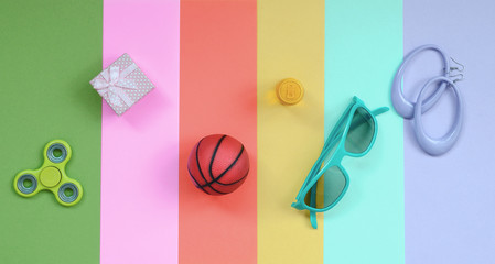 Trendy fashionable pastel composition with earrings, sunglasses, beverage can, basketball ball,...