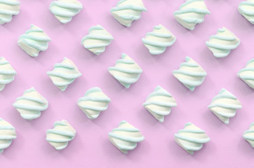 Colorful marshmallow laid out on pink paper background
