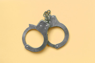 Bdsm and sex games concept. Handcuffs on beige background