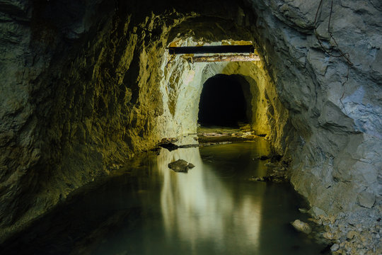 Dark creepy dirty flooded abandoned mine tunnel