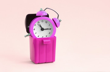 Wasting time concept. Alarm clock in trash bin