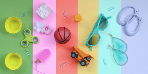 Composition with earrings, sunglasses, beverage can, basketball ball, toy truck, gift box, ice cream, flower and spinner