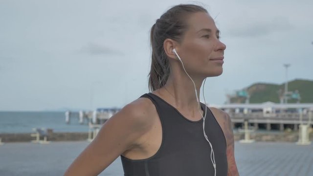 Runner athlete listening to music in headphones from smart phone mp3 player, slow motion, No Color Grading 