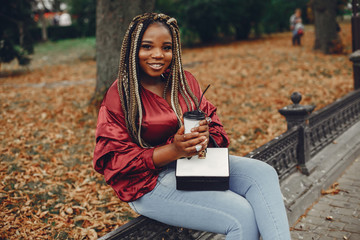 Cute black woman have fun in a city. Beautiful black girl in a red blouse