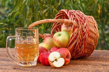 Just picked apples in a wicker basket and apple cider in glass goblet