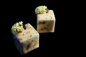 Coffee cube desserts with coffee bean and spring flower isolated on black background