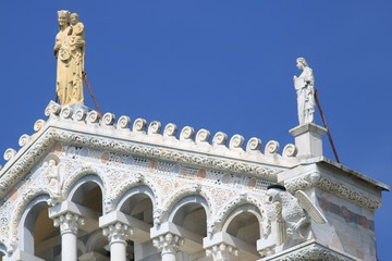 Fototapeta na wymiar Detail of the facade of the Duomo of Pisa with sculptures. The c