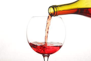 Bright red cocktail pouring to a glass from a bottle