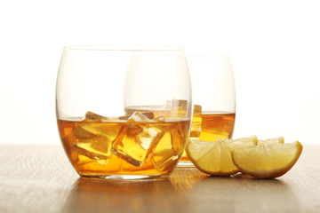 Two glasses with whiskey with ice cubes	
