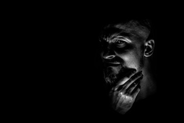  Face with a bearded man grimace against a dark background with sharp shadows. Comedic, fabulous...