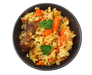 pilaf with meat on black plate isolated on white background. top view