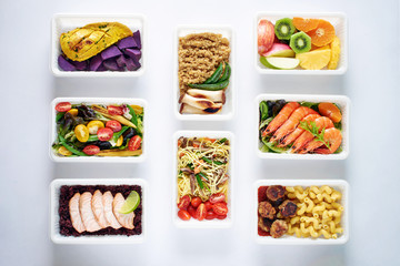 Weekly meal plan concept. Top view of various ready-to-eat dishes: seafood, meat, pasta, noodles, quinoa, veggies and fruits over white background.