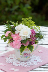 romantischer Blumenstrauß mit Rosen in Weiß und Pink in Teetasse