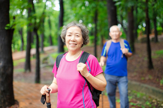 asian senior couple hiking on the forest park