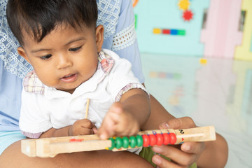 Mom play wooden toy with baby boy
