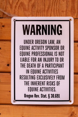 Hillsboro, Oregon \ USA - December 08 2018: Warning sing OR Rev. Stat. 30.691 posted on a barn wall. Liability consent to equine activities.