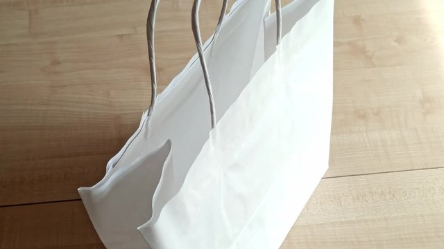 Close up moving up and around a white paper bag as if inspecting it