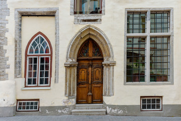 Facade of old gray brick house with wooden door