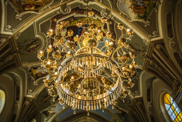 Fototapeta na wymiar Golden lights chandelier in the orthodox church. Luxury design. Religious building.