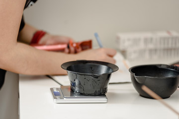 Bowls for hair coloring, hairdresser making notes on the background