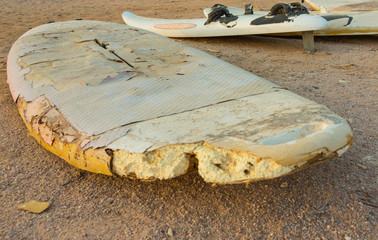 old surfboard lies on the beach