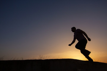 Fototapeta na wymiar silhouette of man running at sunrise