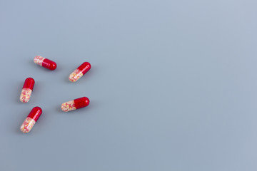 Multicolored pills or capsules on a blue background with copy space.