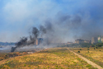 Heavy smoke in steppe. Forest and steppe fires destroy field, steppes during severe droughts. Fire, strong smoke. Blur focus due to shaking hot fire. Disaster, damage, risk to homes. View from drone
