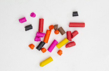 Broken crayons into small pieces isolated on white background.