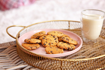 Tasty cookies with glass of milk on tray