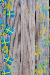 June 6 Sweden independence Day, the concept of the Day of memory of freedom and patriotism. Mini flags with paper confetti on wooden white background. place for text, copy space.