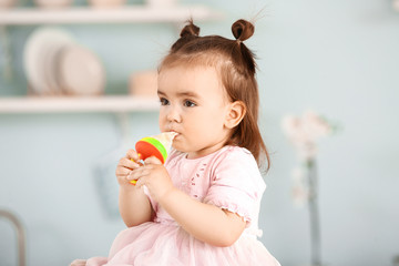 Cute little girl with nibbler in kitchen at home