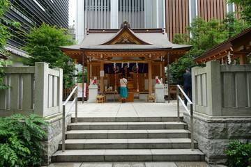 東京の福徳神社にお参りする女性の後ろ姿と参拝客