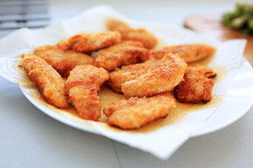 Fried chicken strips drying on the paper