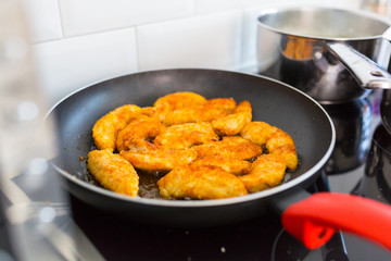 Chicken strips frying on the pan