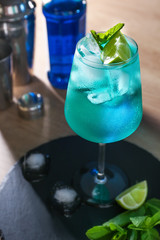 Glass of Blue Lagoon cocktail on table in bar